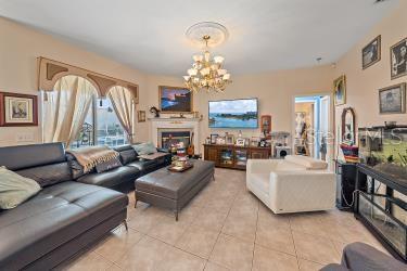 18011 Prairie Wolf Gln, Parrish, FL 34219 - living room featuring tile patterned floors, a notable chandelier, and a fireplace