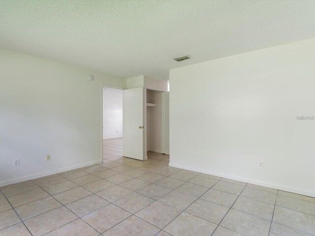 12513 Indiana Woods Ln, Orlando, FL 32824 - empty room with a textured ceiling, light tile patterned floors, and baseboards