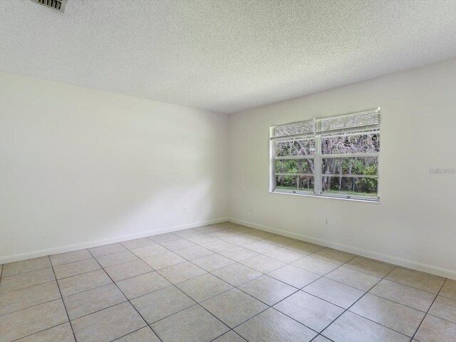 12513 Indiana Woods Ln, Orlando, FL 32824 - unfurnished room with a textured ceiling, light tile patterned floors, and baseboards