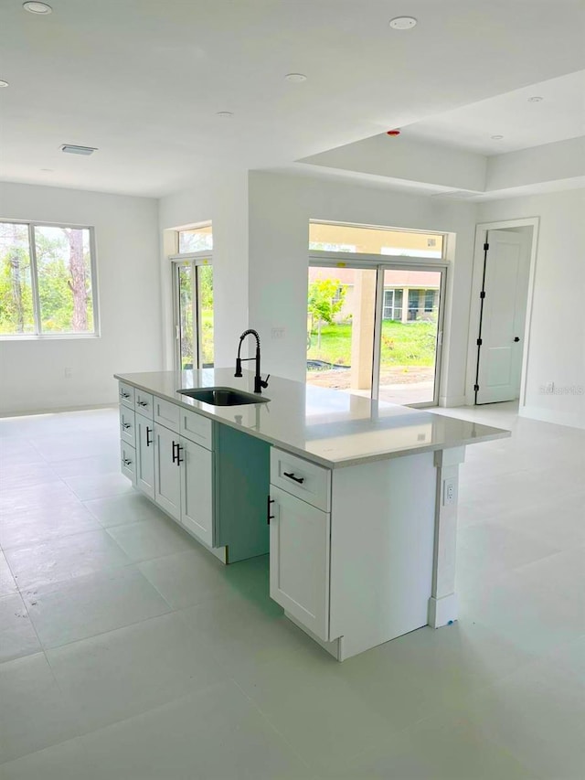 1043 Brenton Ave, Lehigh Acres, FL 33974 - kitchen with a sink, a center island with sink, white cabinetry, light countertops, and recessed lighting