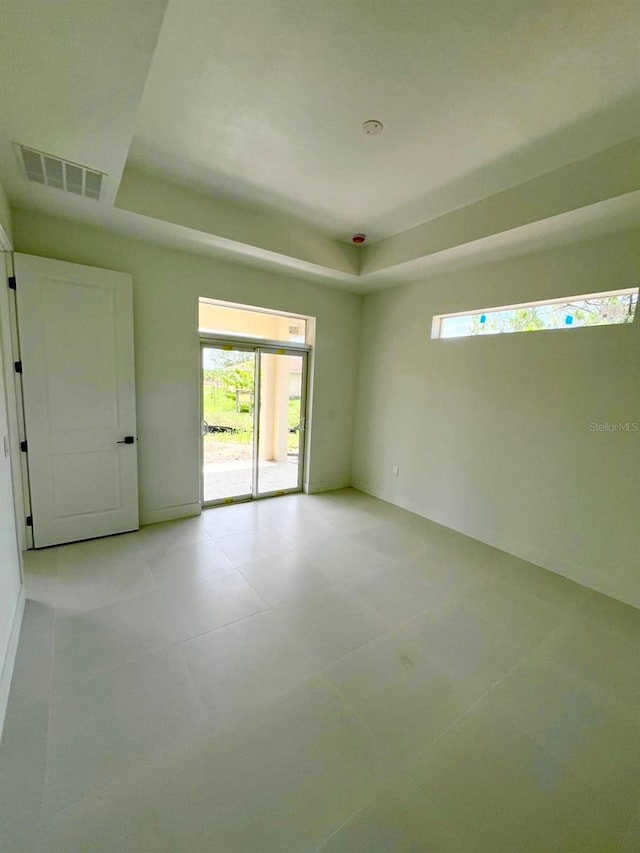 1043 Brenton Ave, Lehigh Acres, FL 33974 - spare room featuring a raised ceiling and light tile patterned flooring