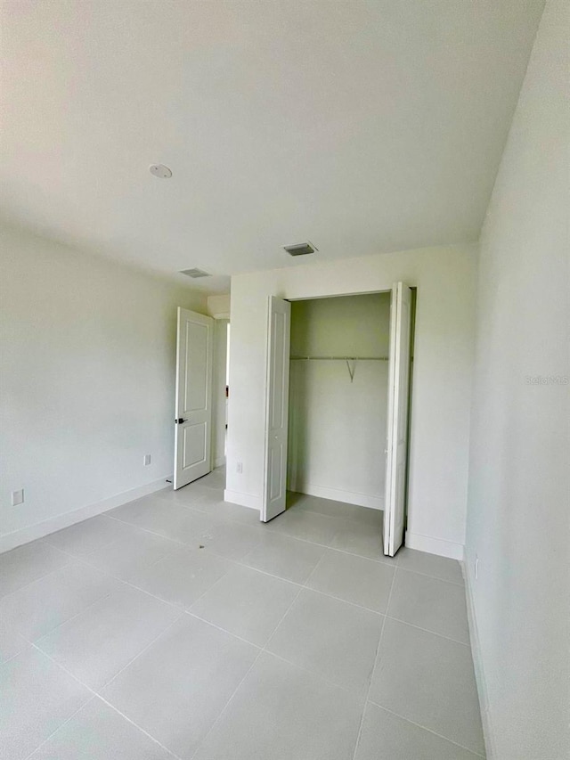 1043 Brenton Ave, Lehigh Acres, FL 33974 - unfurnished bedroom featuring baseboards, light tile patterned floors, and a closet