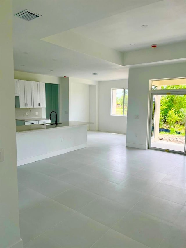 1043 Brenton Ave, Lehigh Acres, FL 33974 - unfurnished living room featuring a sink and light tile patterned floors
