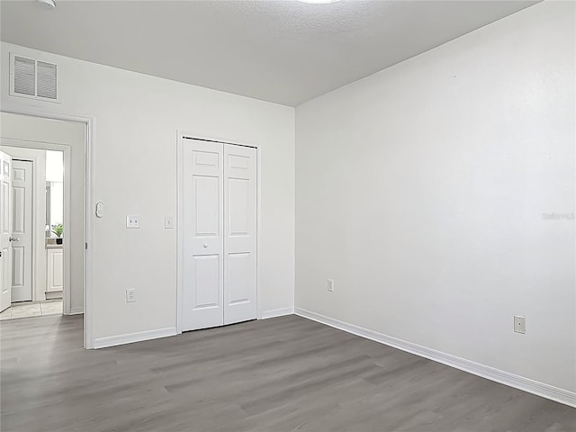 5550 E Michigan St Unit 2214, Orlando, FL 32822 - unfurnished bedroom featuring wood finished floors, baseboards, a closet, and visible vents