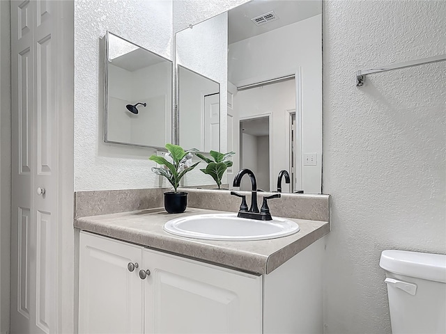 5550 E Michigan St Unit 2214, Orlando, FL 32822 - bathroom featuring toilet, vanity, a textured wall, and visible vents