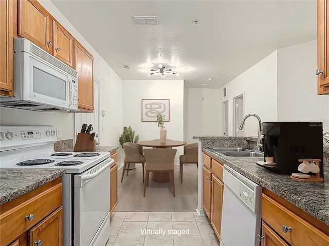 5550 E Michigan St Unit 2214, Orlando, FL 32822 - kitchen with visible vents, a sink, dark countertops, white appliances, and brown cabinetry
