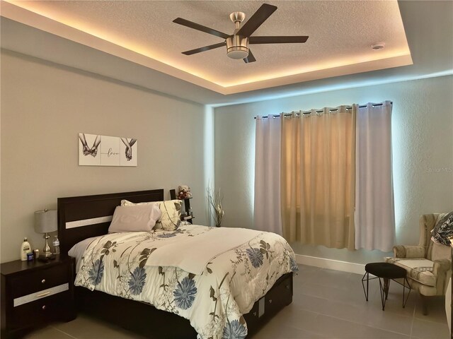 1804 Hudson Ct, Poinciana, FL 34759 - tiled bedroom featuring ceiling fan, a textured ceiling, and a raised ceiling