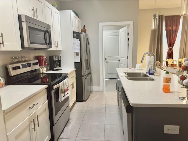 1804 Hudson Ct, Poinciana, FL 34759 - kitchen with light tile patterned floors, an island with sink, appliances with stainless steel finishes, a sink, and hanging light fixtures