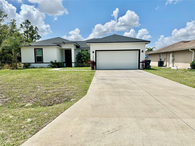 1804 Hudson Ct, Poinciana, FL 34759 - view of front of home featuring central AC, an attached garage, concrete driveway, stucco siding, and a front lawn