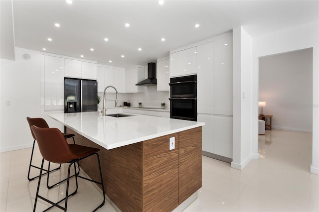 kitchen with wall chimney exhaust hood, modern cabinets, white cabinets, black appliances, and a sink