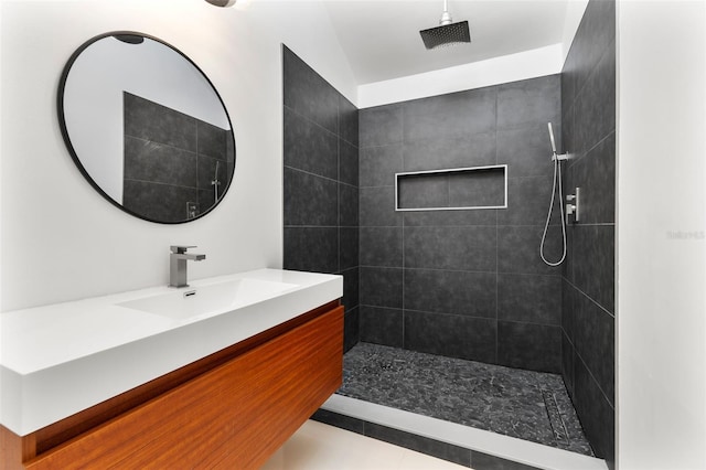 full bathroom with tiled shower and vanity