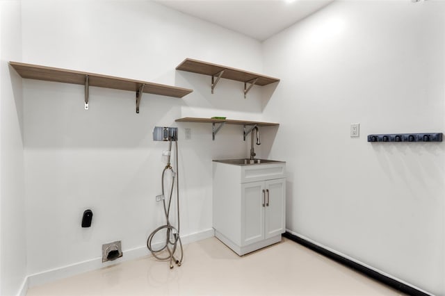 washroom featuring indoor wet bar, washer hookup, baseboards, and cabinet space