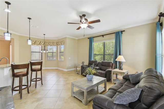 living room with light tile patterned flooring, crown molding, a ceiling fan, and baseboards