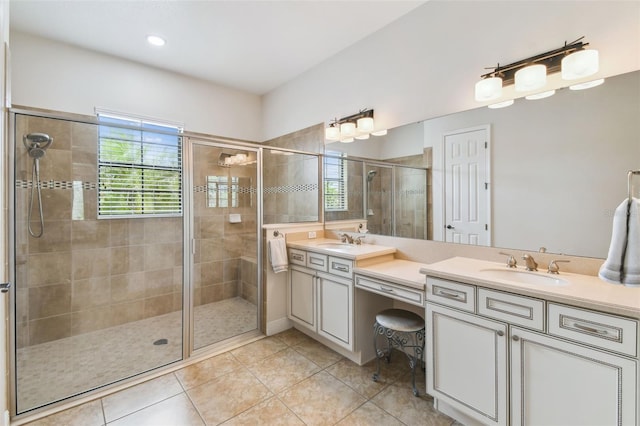 bathroom with double vanity, a healthy amount of sunlight, a shower stall, and a sink
