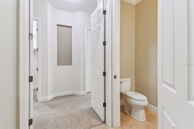 bathroom with toilet and baseboards