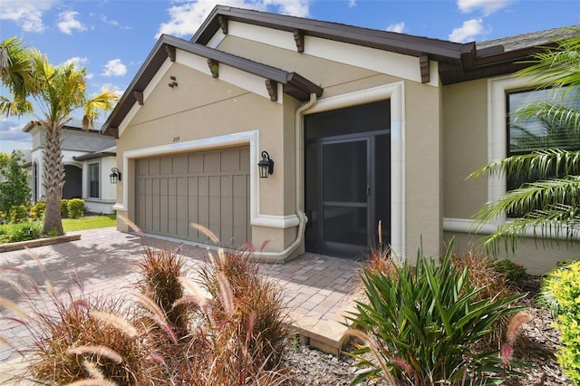 204 Bella Cortina Dr, Kissimmee, FL 34759 - view of front of home featuring an attached garage, stucco siding, and decorative driveway