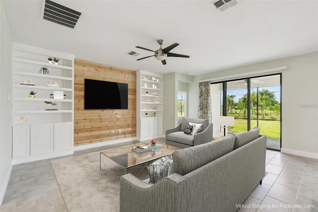 204 Bella Cortina Dr, Kissimmee, FL 34759 - living area with wooden walls, baseboards, a ceiling fan, built in shelves, and light tile patterned flooring