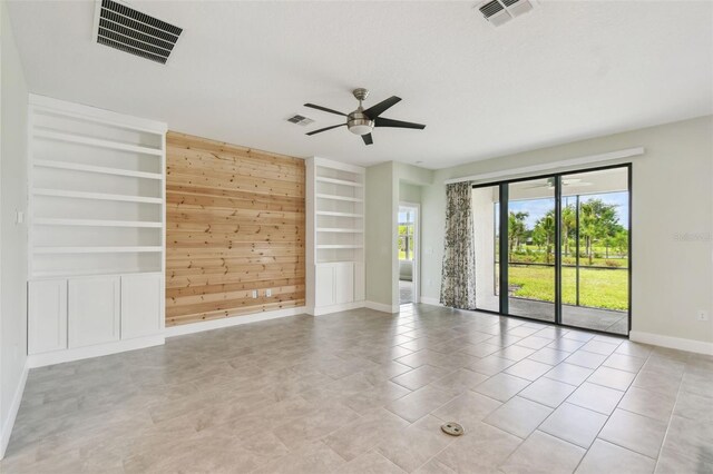 204 Bella Cortina Dr, Kissimmee, FL 34759 - empty room with baseboards, a ceiling fan, wood walls, built in features, and light tile patterned floors