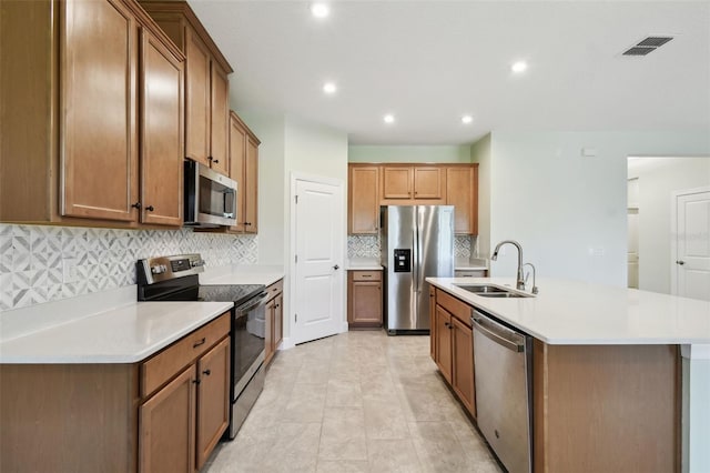 204 Bella Cortina Dr, Kissimmee, FL 34759 - kitchen with stainless steel appliances, a sink, an island with sink, tasteful backsplash, and light countertops