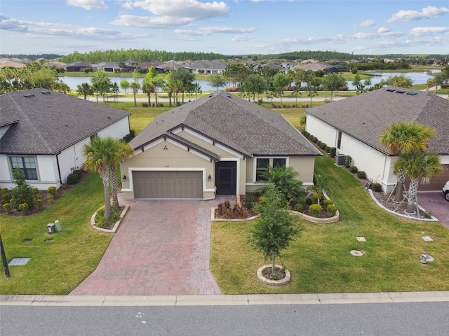 204 Bella Cortina Dr, Kissimmee, FL 34759 - view of front of house with a garage, decorative driveway, stucco siding, and a water view