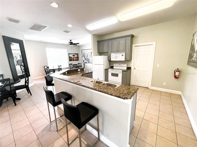 4871 Coral Castle Dr, Kissimmee, FL 34746 - kitchen featuring visible vents, gray cabinetry, white appliances, and light tile patterned floors