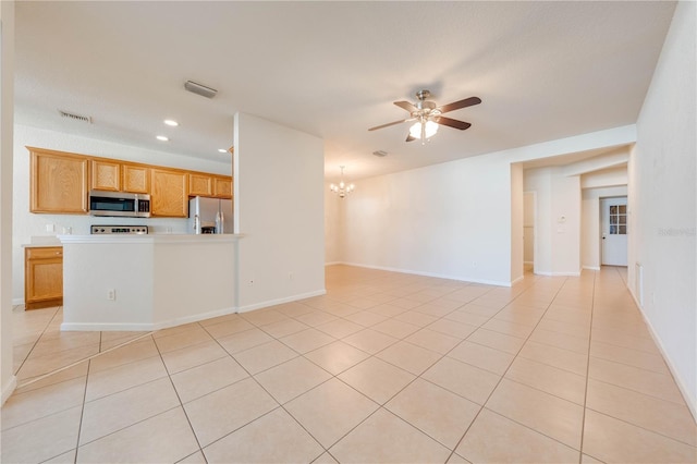 unfurnished living room featuring ceiling fan with notable chandelier, light tile patterned flooring, baseboards, and visible vents