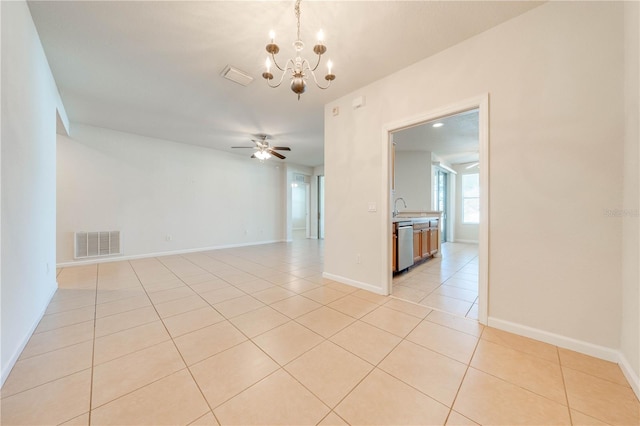 spare room featuring ceiling fan with notable chandelier, light tile patterned floors, visible vents, a sink, and baseboards