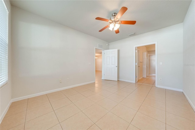 unfurnished bedroom featuring light tile patterned floors, baseboards, a ceiling fan, and visible vents