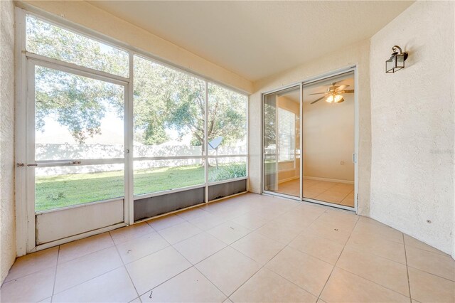 unfurnished sunroom with a ceiling fan