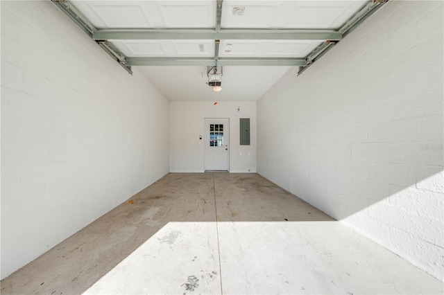 garage with concrete block wall, a garage door opener, and electric panel