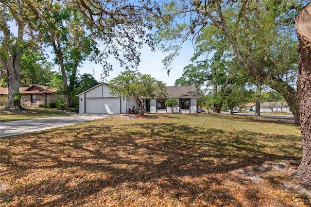 single story home with an attached garage, concrete driveway, and a front lawn