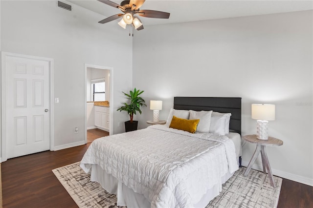 bedroom with ensuite bath, a ceiling fan, visible vents, wood finished floors, and baseboards