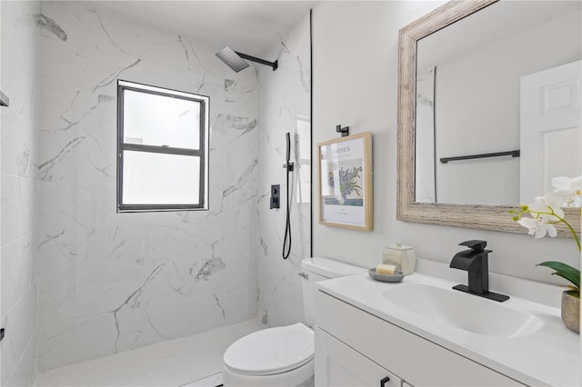 bathroom featuring toilet, a marble finish shower, and vanity