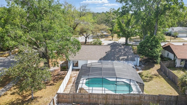 view of pool with a fenced in pool, a fenced backyard, and glass enclosure