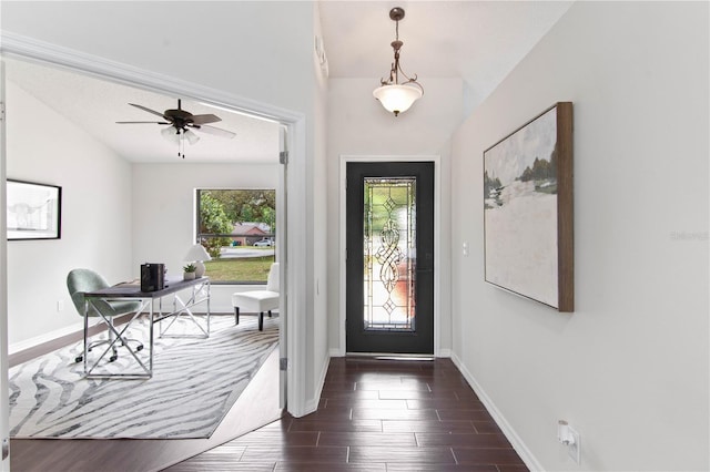 foyer entrance with dark wood-style flooring, baseboards, and a ceiling fan