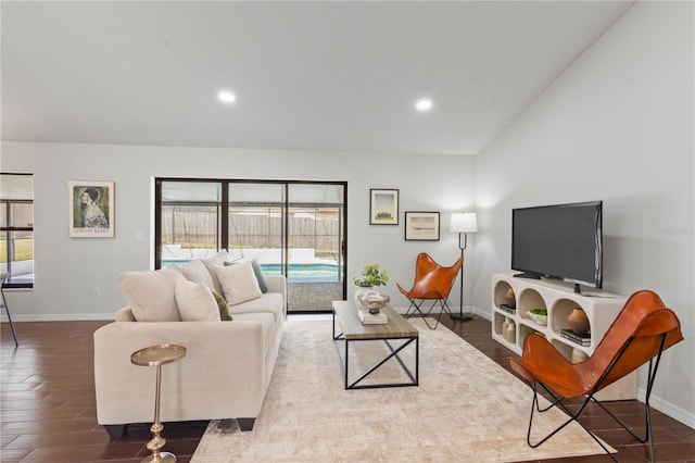 living area featuring wood finished floors, baseboards, lofted ceiling, and recessed lighting