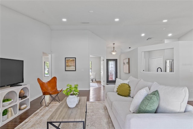 living area featuring vaulted ceiling, visible vents, recessed lighting, wood finished floors, and baseboards