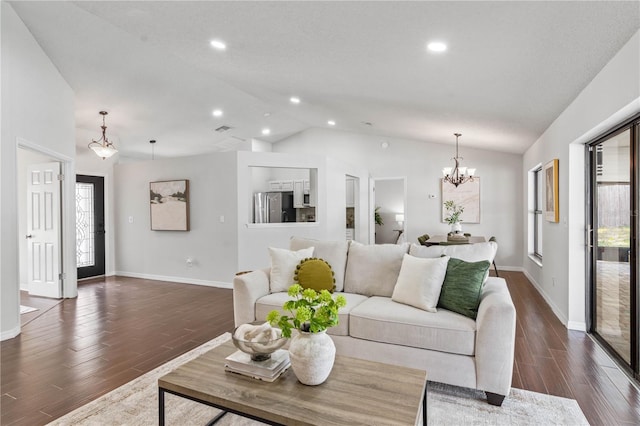living room featuring dark wood-type flooring, an inviting chandelier, baseboards, and vaulted ceiling