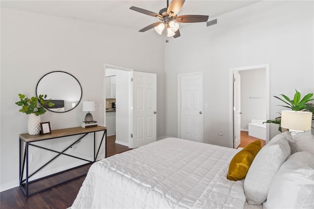 bedroom with dark wood-style flooring, visible vents, baseboards, and high vaulted ceiling