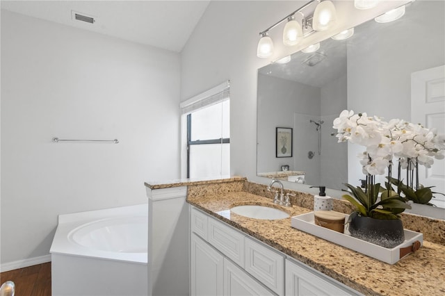 bathroom with vanity, visible vents, a bath, a shower, and wood finished floors