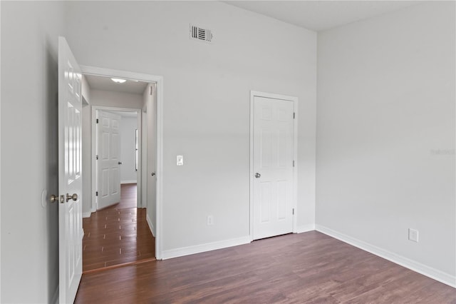 unfurnished bedroom featuring wood finished floors, baseboards, and visible vents