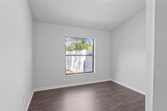 unfurnished room featuring baseboards, a textured ceiling, and dark wood finished floors