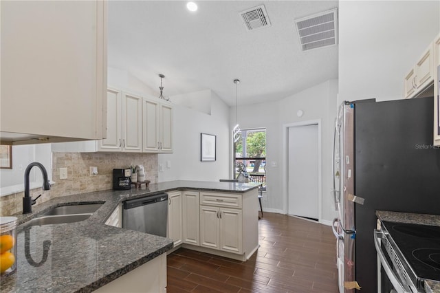 kitchen featuring a sink, visible vents, a peninsula, and stainless steel appliances