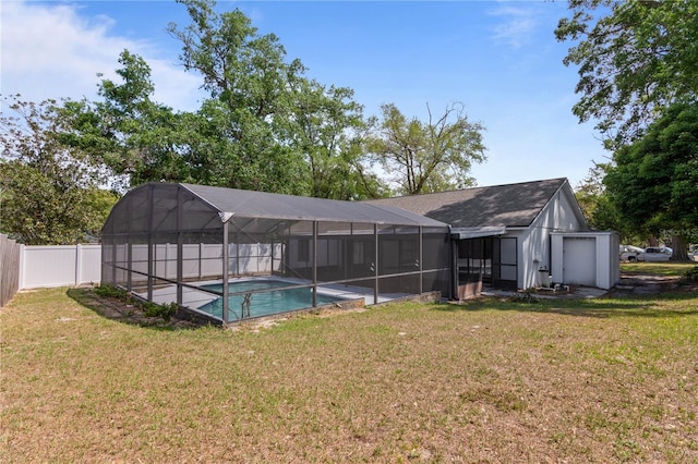 back of property with a fenced in pool, a fenced backyard, glass enclosure, and a lawn