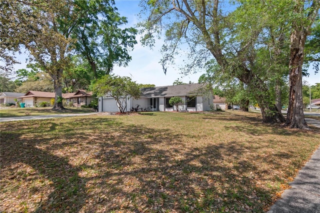 ranch-style house with a front yard, driveway, stucco siding, and an attached garage