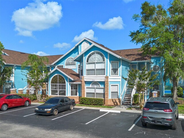 2745 N Poinciana Blvd Unit 65, Kissimmee, FL 34746 - view of building exterior featuring stairs and uncovered parking