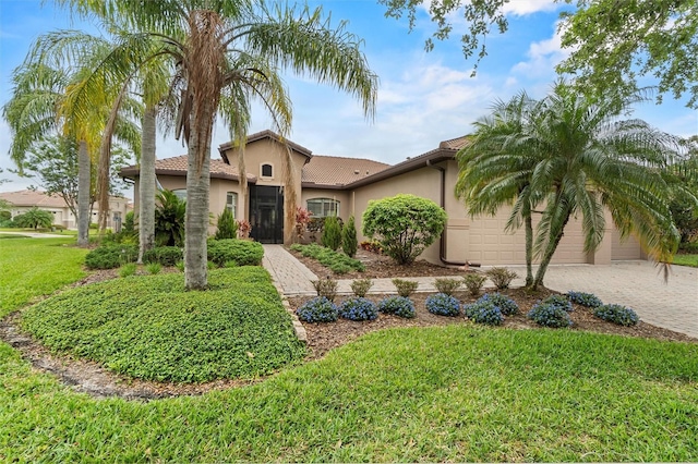 469 Sorrento Rd, Kissimmee, FL 34759 - mediterranean / spanish home with stucco siding, driveway, a front lawn, a tile roof, and a garage