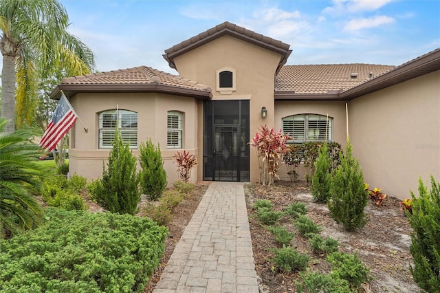 469 Sorrento Rd, Kissimmee, FL 34759 - doorway to property featuring a tile roof and stucco siding