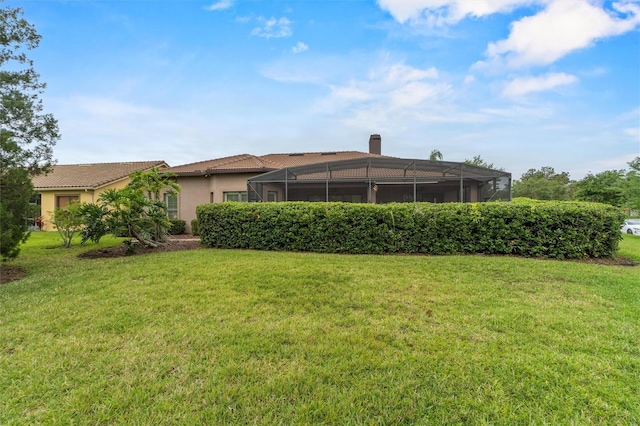 469 Sorrento Rd, Kissimmee, FL 34759 - back of house with stucco siding, a lanai, a lawn, and a tile roof