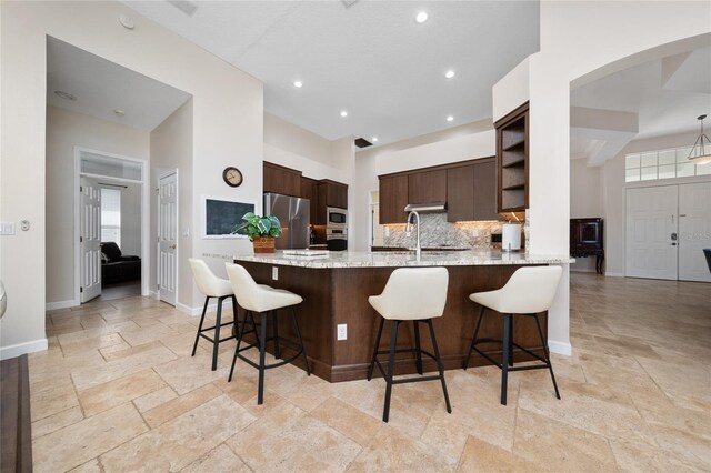 9509 Baycliff Ct, Orlando, FL 32836 - kitchen with freestanding refrigerator, stone tile floors, a peninsula, dark brown cabinets, and recessed lighting
